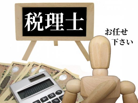 お金の上に置かれた電卓と木製の人形